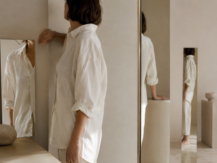Femme en tenue claire photographiée avec plusieurs reflets montrant différents fragments de sa silhouette.