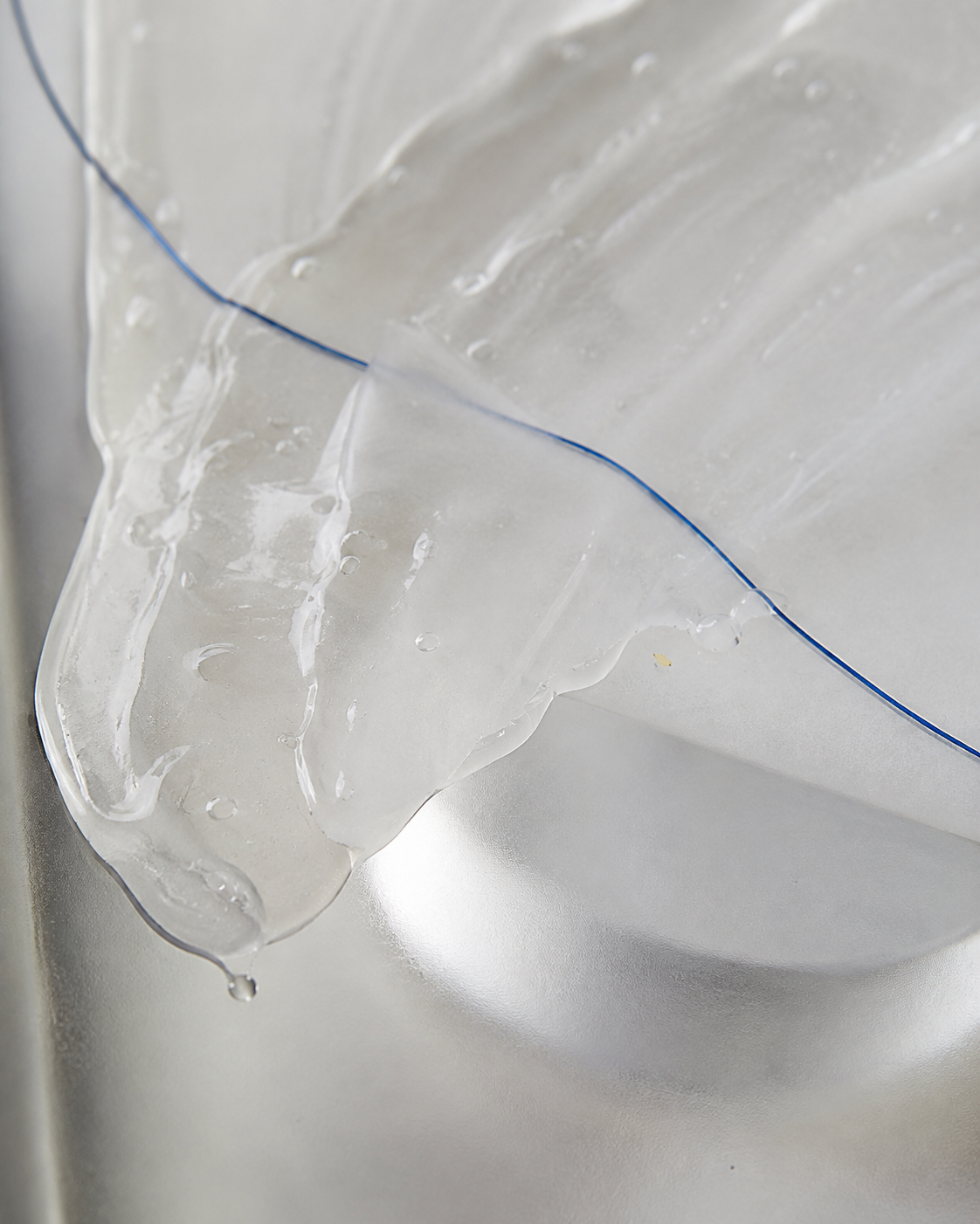 Texture translucide de soin en cours de formulation avec un fil bleu BERYT